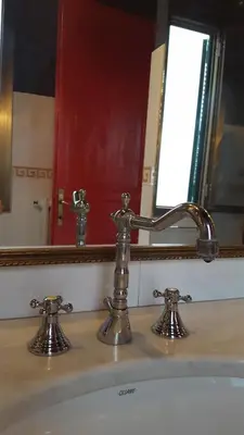 a bathroom sink with a faucet in front of a mirror at Casa di Walter al Pigneto in Rome