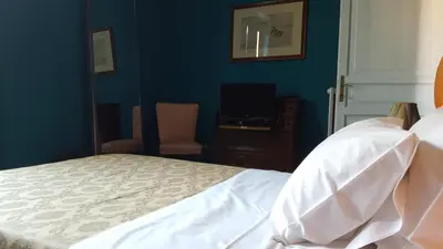 a bedroom with a white bed and a television at Casa di Walter al Pigneto in Rome