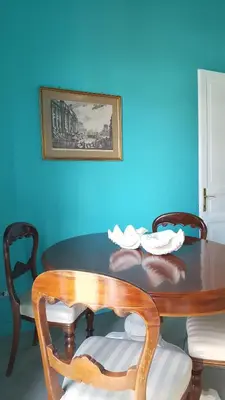a dining room table with chairs and a blue wall at Casa di Walter al Pigneto in Rome