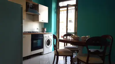 a kitchen with a table and a washing machine at Casa di Walter al Pigneto in Rome