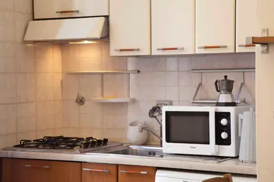 a microwave sitting on top of a stove in a kitchen at Monti house in Rome