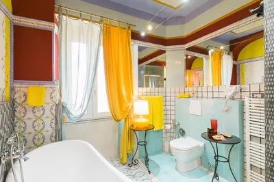 a bathroom with yellow curtains and a toilet at Appartamenti MarcoAurelio49 in Rome