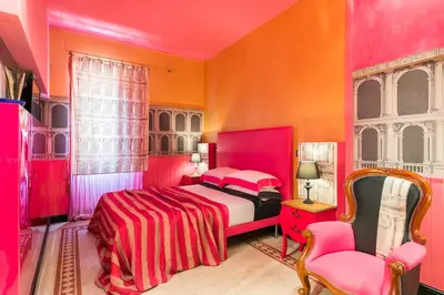 a colorful bedroom with a bed and a chair at Appartamenti MarcoAurelio49 in Rome