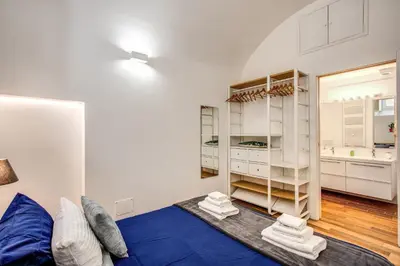 a living room with a blue bed and white cabinets at FRESH HOUSE NAVONA in Rome