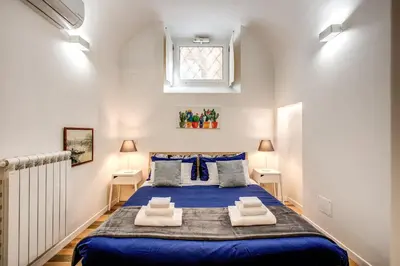 a bedroom with a large blue bed in a room at FRESH HOUSE NAVONA in Rome