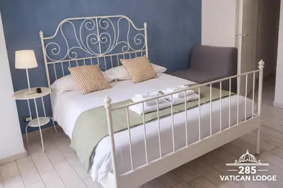 a bedroom with a large white bed with towels on it at 285 Vatican Lodge in Rome