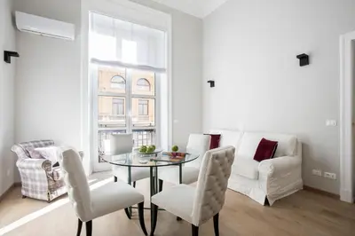 a living room with a table and chairs and a couch at SPA Apartment Via Barberini in Rome