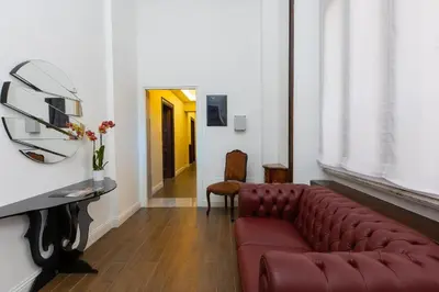 a living room with a red couch and a hallway at SPA Apartment Via Barberini in Rome