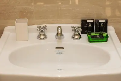 a white bathroom sink with a chrome faucet at SPA Apartment Via Barberini in Rome