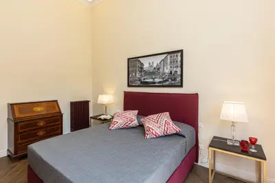 a bedroom with a bed with two lamps and a dresser at SPA Apartment Via Barberini in Rome