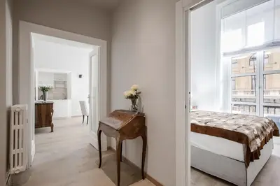 a bedroom with a bed and a table with flowers on it at SPA Apartment Via Barberini in Rome