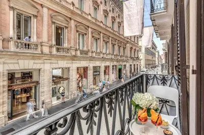 a balcony with a table and chairs on a city street at Hotel 55 Fifty-Five - Maison d'Art Collection in Rome