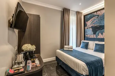 a hotel room with a bed and a flat screen tv at Hotel 55 Fifty-Five - Maison d'Art Collection in Rome