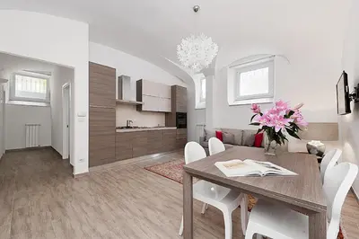 a dining room and kitchen with a table and chairs at BMGA l Mon Amour San Giovanni Apartment in Rome