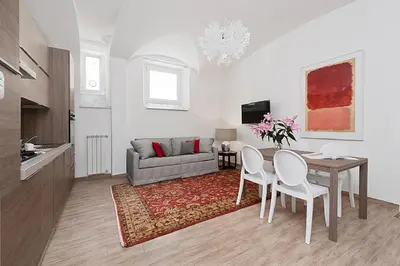 a living room with a table and a couch at BMGA l Mon Amour San Giovanni Apartment in Rome