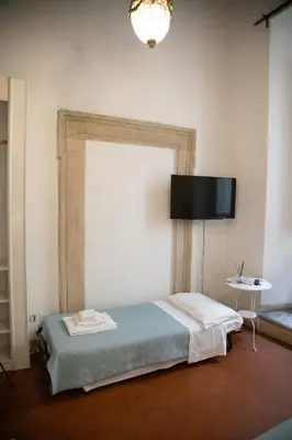 a bedroom with a bed and a television on the wall at Flowers Apartments Rome City Center in Rome