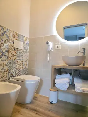 a bathroom with a sink and a toilet and a mirror at AmoRoma Suite in Rome