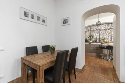 a dining room with a wooden table and black chairs at Take You Rome - Vatican Apartment in Rome