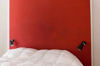 a bedroom with a red wall and a bed at Gli Alberi a Testaccio in Rome