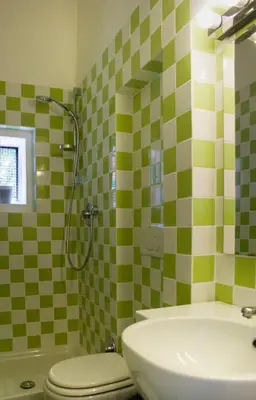 a bathroom with a green and white tiled wall at Gli Alberi a Testaccio in Rome