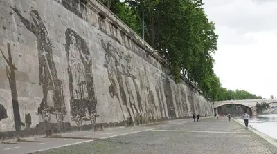 a wall with paintings on it next to a river at Gli Alberi a Testaccio in Rome