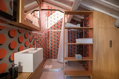 a bathroom with a sink and a wall with orange circles at Flat PIAZZA DEL POPOLO in Rome