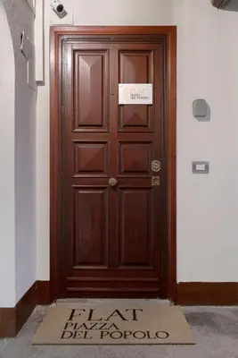 a wooden door in a building with a sign on it at Flat PIAZZA DEL POPOLO in Rome