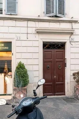 a scooter parked in front of a building with a brown door at Flat PIAZZA DEL POPOLO in Rome