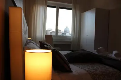 a bedroom with a bed and a large window at Panoramic View of St. Peter in Rome