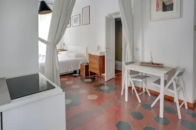 a room with a bed and a table and a desk at Charming Colosseum in Rome