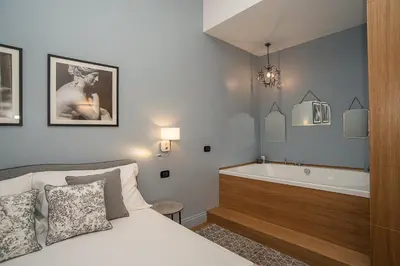 a bedroom with a bed and a bath tub at LikeYourHome, 80 sq m luxury apartment with Jacuzzi, in Trastevere district in Rome