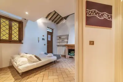 a living room with a couch and a fireplace at Amazing studio in Campo de Fiori - FromHometoRome in Rome