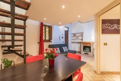 a living room with a table and red chairs at Amazing studio in Campo de Fiori - FromHometoRome in Rome