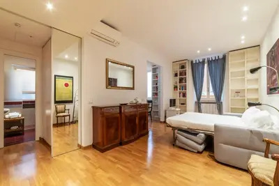 a bedroom with a bed and a couch and a mirror at Apartment with terrace near Piazza Navona - FromHometoRome in Rome