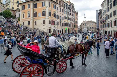 a horse drawn carriage on a city street with people at The Inn at the Spanish Steps Luxury Collection - Premium Studio Room in Rome