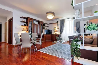 a dining room and living room with a table and chairs at Colosseo Sunset Apartment in Rome