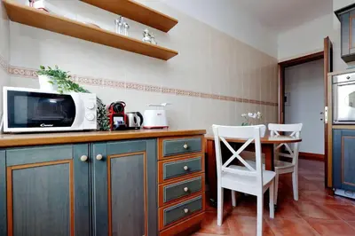 a kitchen with a microwave and a table and chairs at Colosseo Sunset Apartment in Rome