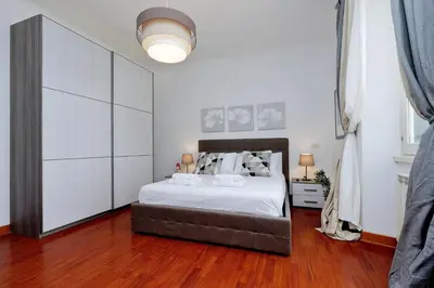 a bedroom with a large bed with white cabinets at Colosseo Sunset Apartment in Rome