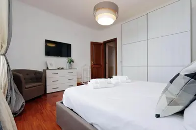 a bedroom with a large white bed and a couch at Colosseo Sunset Apartment in Rome