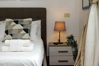 a bedroom with a bed and a lamp on a night stand at Colosseo Sunset Apartment in Rome
