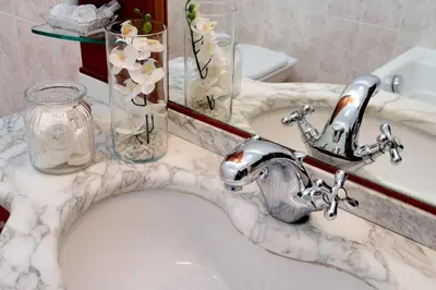 a bathroom sink with a faucet and a mirror at Colosseo Sunset Apartment in Rome