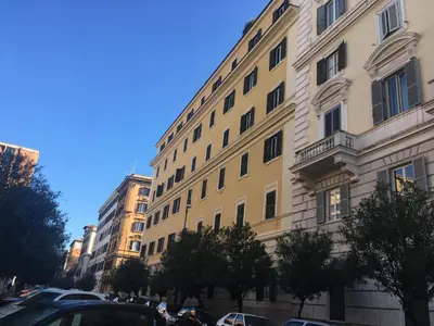 a large building with cars parked in front of it at Colosseo Sunset Apartment in Rome