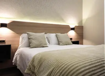 a bedroom with a large bed with white sheets and pillows at My Maison 70 Guest House in Rome
