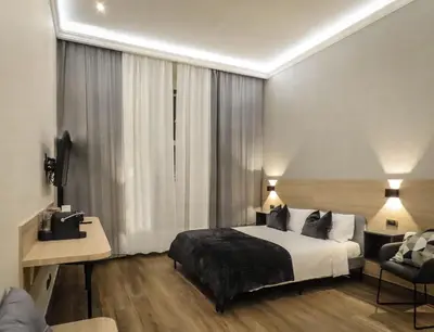 a bedroom with a bed and a chair in a room at My Maison 70 Guest House in Rome