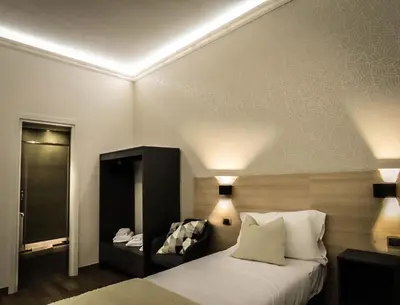 a hotel room with a bed and a chair at My Maison 70 Guest House in Rome