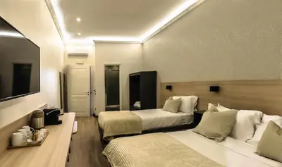 a hotel room with two beds and a table at My Maison 70 Guest House in Rome