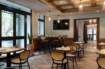 a restaurant with tables and chairs and windows at DoubleTree By Hilton Rome Monti in Rome
