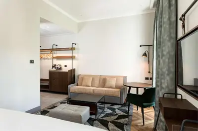 a living room with a couch and a table at DoubleTree By Hilton Rome Monti in Rome