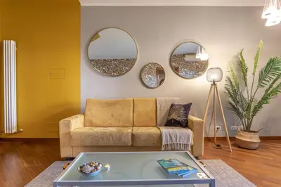 a living room with a couch and two mirrors at Kitty Apartment - Close to the Vatican in Rome