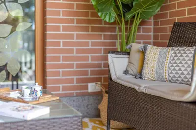 a wicker chair with a pillow on a patio at Kitty Apartment - Close to the Vatican in Rome